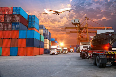集装箱货物运输的物流进出口图片-有货运飞机飞过的天空下的集装箱货物 .